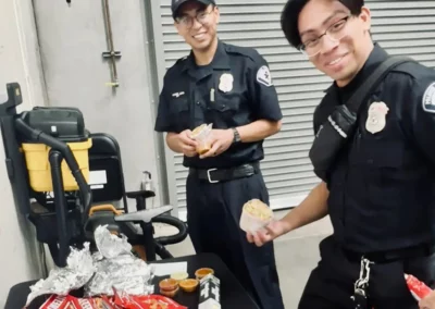 Two EMS workers show off burritos and snacks
