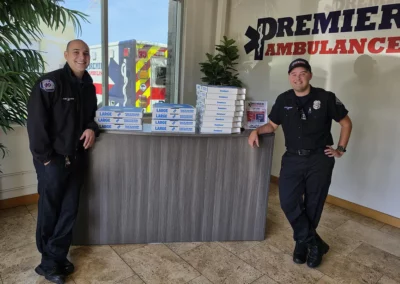 EMS workers pose with a stack of pizzas