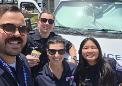 EMS workers smile in front of their ambulance
