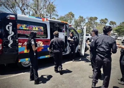 A group of EMS workers hanging out and eating pizza next to their ambulance