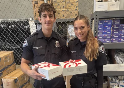 Two EMS workers smile, holding up Chik-fil-a boxes