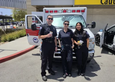 Three EMS workers stand in front of their ambulance and enjoy burritos.