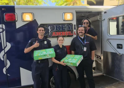 Four EMS workers entering an ambulance with large boxes of Subway sandwiches.