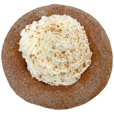 Circular doughnut covered in cinnamon sugar and topped with a dollop of whipped cream