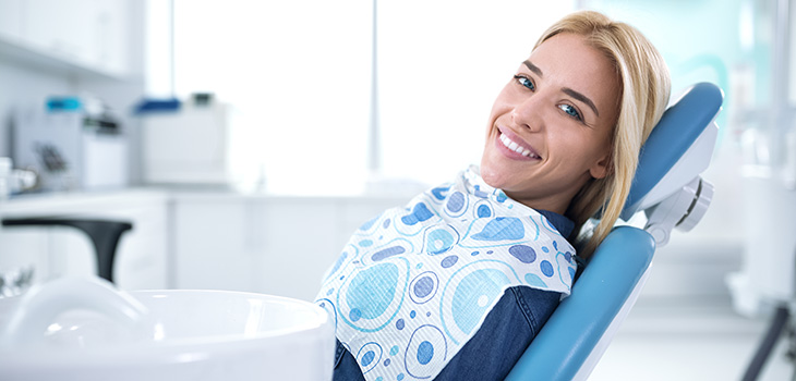 Smiling blonde woman reclined in a dental chair