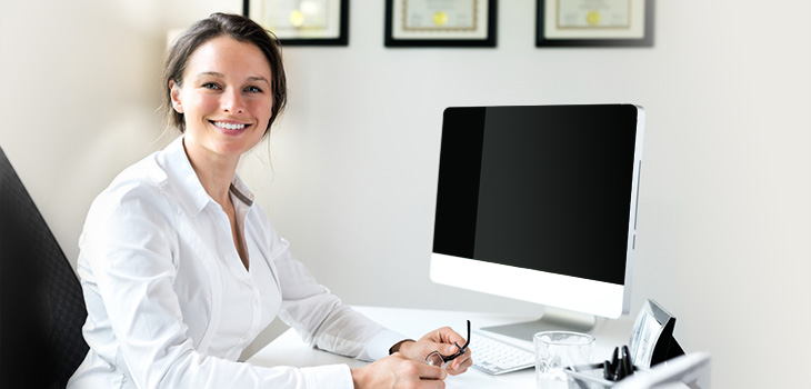Doctor sitting at her desk with her glasses in her hands