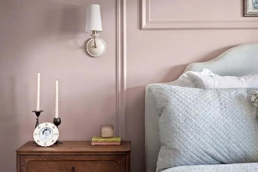 A nightstand with books, candles, and a photo of a girl