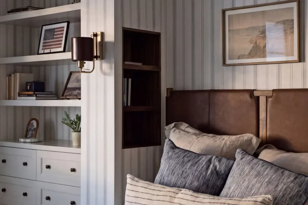 A bed next to built in bookcases