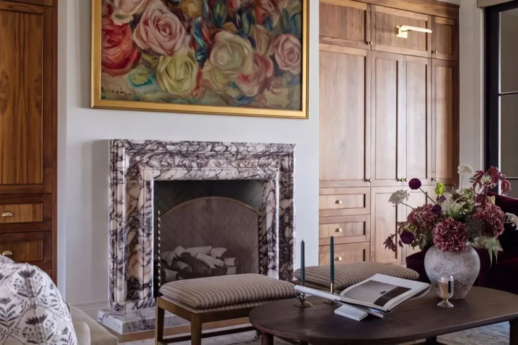 A marble fireplace next to wooden cabinets and a sitting area