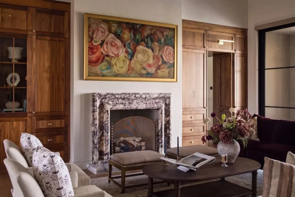 A marble fireplace next to wooden cabinets and a sitting area