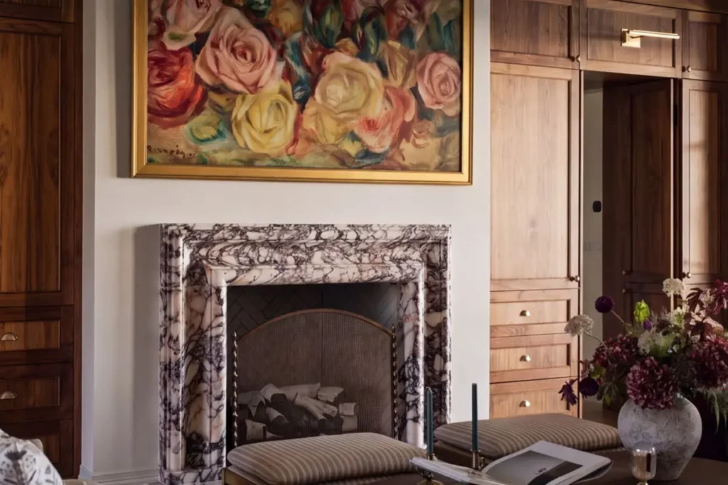 A marble fireplace next to wooden cabinets and a sitting area