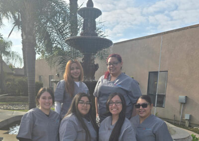A group of Prosperity graduates standing in front of a fountain