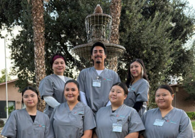 A group of Prosperity graduates standing in front of a fountain