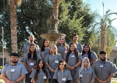 A group of Prosperity graduates standing in front of a fountain
