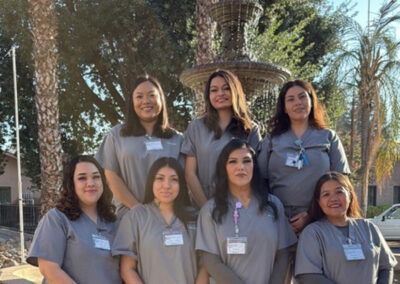 A group of Prosperity graduates standing in front of a fountain