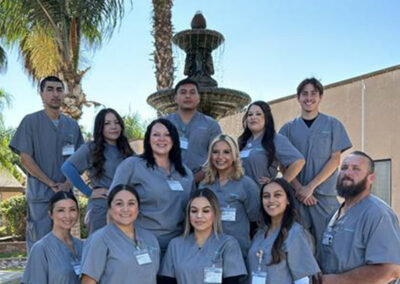A group of Prosperity graduates standing in front of a fountain