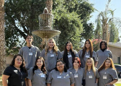 A group of Prosperity graduates standing in front of a fountain