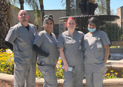 Four Prosperity graduates standing in front of a fountain