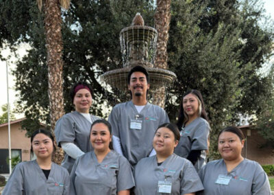 A group of Prosperity graduates standing in front of a fountain