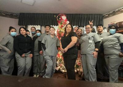 A group of Prosperity nurses in front of a Christmas tree